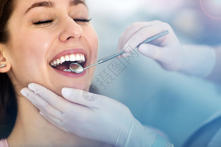 在牙医那里检查牙齿的女人背景图片