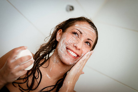 在浴室用肥皂洗脸的图片