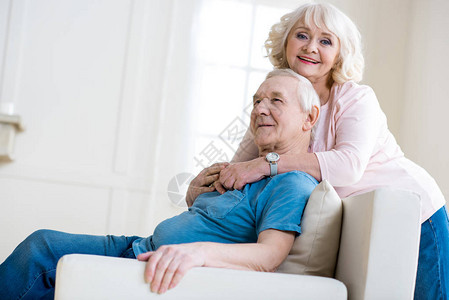 快乐的老年情侣在家拥抱和背景图片
