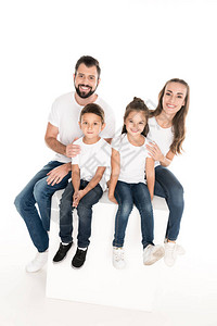 家庭幸福孩子们坐在白方块上孤图片