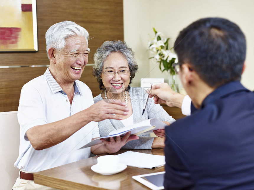 快乐的老年亚裔夫妇准备签署合同从销售代表图片