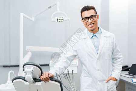 英俊的非裔美国牙医笑着站在口袋图片