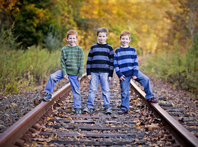 站在旧铁轨上的三兄弟图片