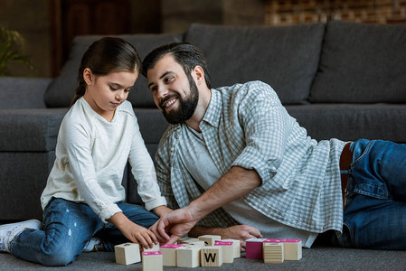 快乐的父亲和女儿在家中用字母说话图片