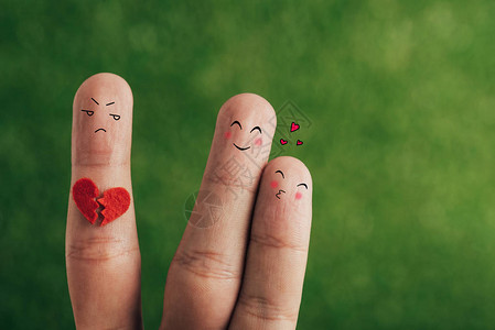 将手指视为爱情的幸福情侣和心碎在绿色图片