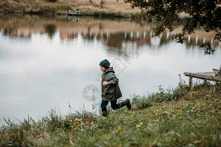 小男孩在湖边的草地图片