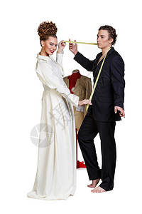 测量一名商人的西装或改变他穿的衣服的时尚女裁缝图片