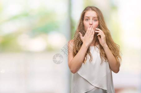 用智能手机捂嘴的年轻金发女子因错误感到羞耻恐惧的表达沉默中的害怕秘密图片