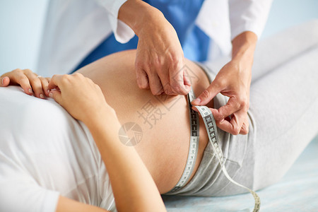 产科医生测量怀孕患者的腹部图片