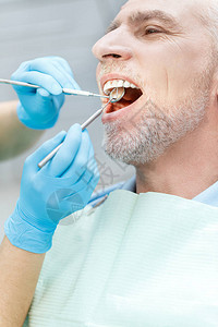 牙科门诊中牙医治疗成熟病人的近视图片