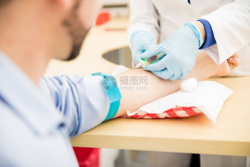 男病人在诊所接受血检时抽取血液图片