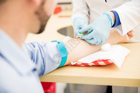 男病人在诊所接受血检时抽取血液图片