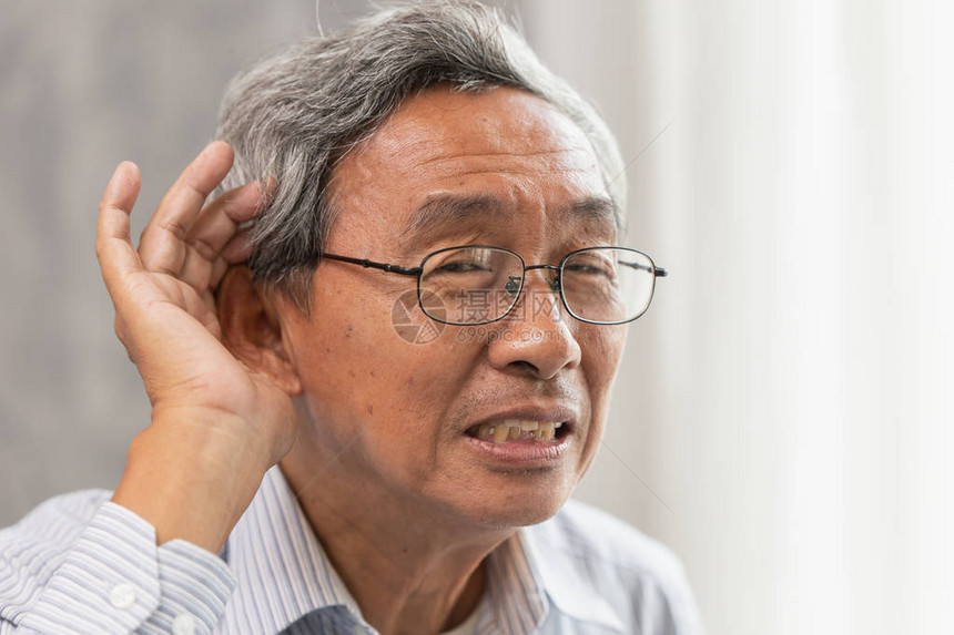 听力有问题的亚洲老人举起手来帮助倾图片