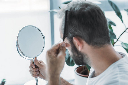 中年男子梳理头发照镜子图片