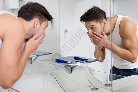 年轻人在浴室洗脸图片