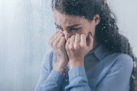 压抑的女人用双手蒙住脸用雨滴图片