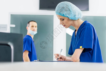 女外科医生在医院看她时撰写诊断书图片