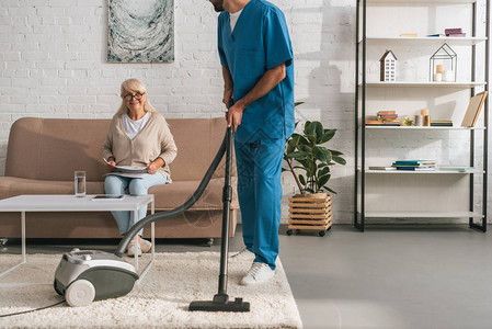 社会工作者用吸尘清洁器清洗地毯图片