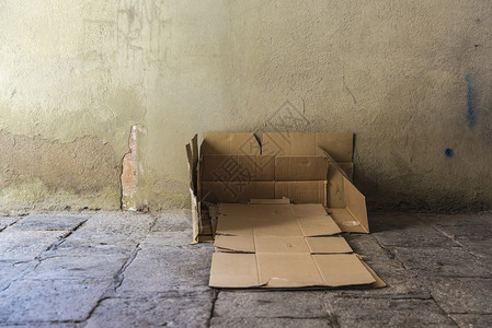 床是一位无家可归的男子在巴塞罗那旧城一条街上用一块旧石地板盖背景图片