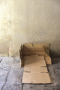 床是一位无家可归的男子在巴塞罗那旧城一条街上用一块旧石地板盖背景图片