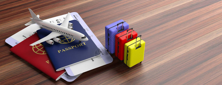 木制背景横幅复印空间上的两本护照手提箱和机票图片