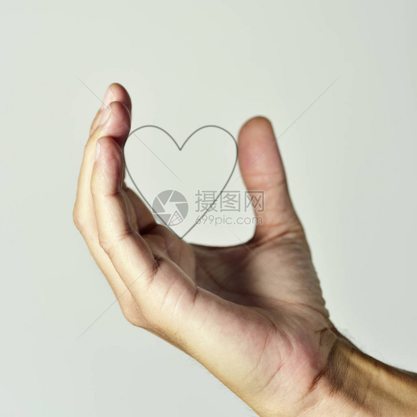 一个年轻的天主教男子的手紧地握着心脏的侧写在非白种图片