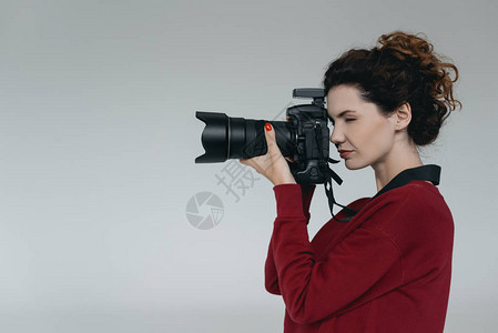 女专业摄影师照片制室有数码摄影相机在图片