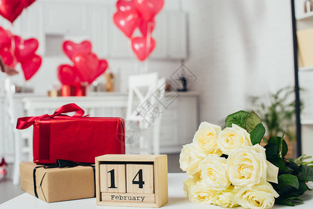 带有丝带玫瑰花束和日历的礼品盒图片