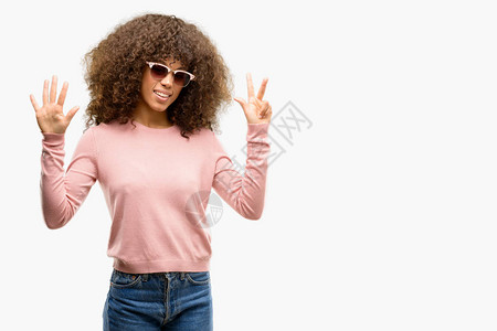 身戴粉红色太阳镜的非洲美妇女展示和指着第八指图片