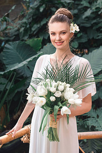 在热带花园中用婚礼花束装饰着白色礼图片