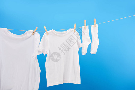 白色的干净白色T恤衫和袜子挂在紧贴着蓝色图片