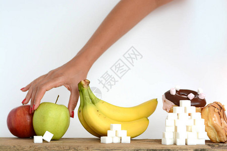 妇女选择健康饮食在新鲜水果和甜食之间图片