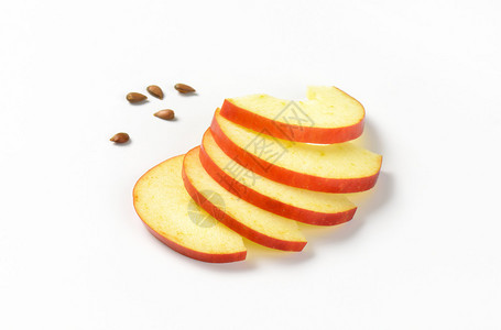 白色背景上的薄苹果片和种子图片