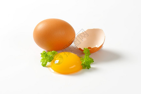新鲜的蛋黄整个棕色鸡蛋和壳图片