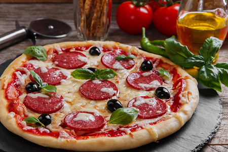 黑石头上的意大利腊肠番茄和奶酪披萨图片