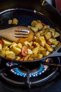 用木勺在平底锅里炒土豆图片