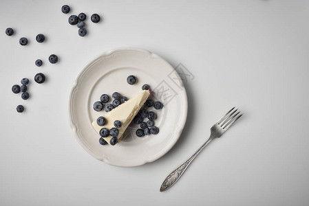 夹蓝莓在盘子上的芝士蛋糕图片