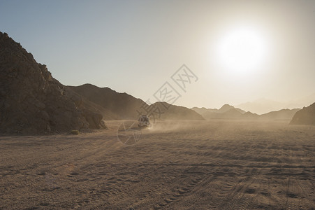 穿越干旱荒漠的沙漠风景和日落乘越图片