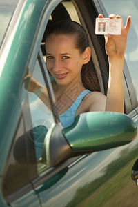 拿着驾驶执照的女人在背景图片
