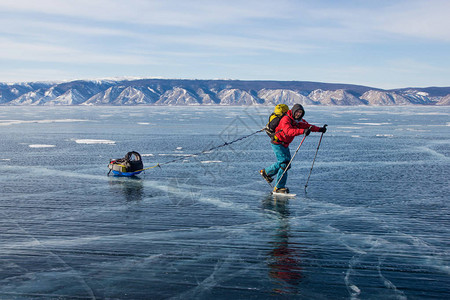 在冰水表面行走的背包男子徒步旅行者背景图片