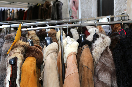 跳蚤市场出售的冬季夹克毛皮大衣挂背景图片