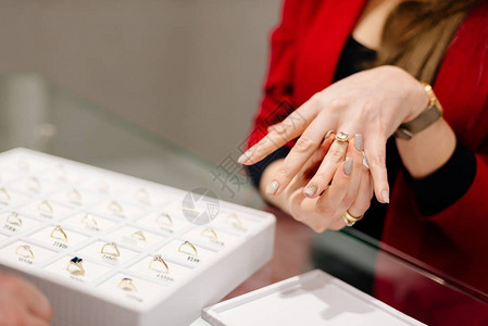 一家豪华珠宝店的女卖家展示了一枚戒指购买订婚戒指珠宝图片