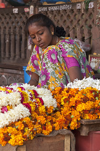 在印度拉贾斯坦邦斋浦尔的一个摊位上卖花草的印度女人图片
