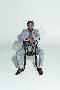 坐在椅子后坐着看摄影机的非洲帅哥美国男人图片