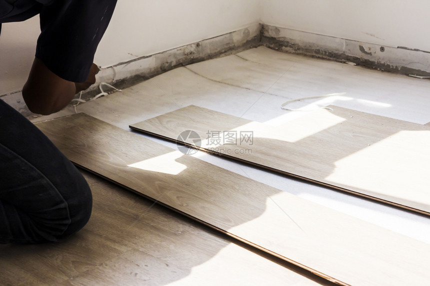 男人在卧室里修理强化木地板图片
