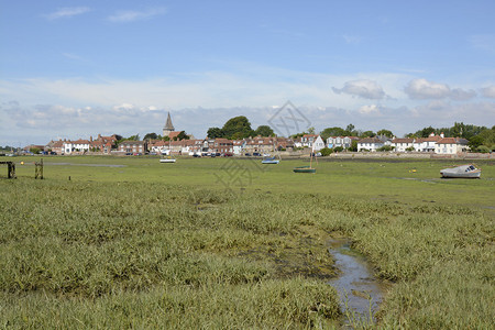 奇切斯特港的Bosham村西萨塞克斯英国低潮与海藻和搁浅的小背景图片
