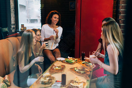 四个快乐的女朋友在快餐厅聊天愉快图片