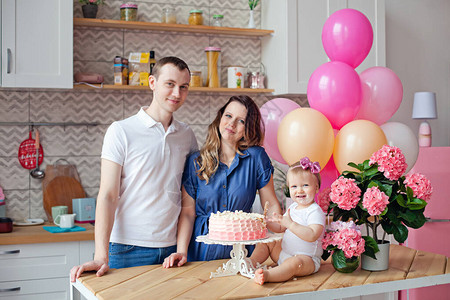 餐桌上的一家人拿着生日蛋糕和气球背景图片