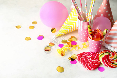浅色背景中带有糖果的生日派对用品图片