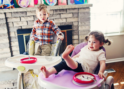 可爱的白种人儿童双胞胎兄弟姐妹坐在高脚椅上吃麦片的肖像图片